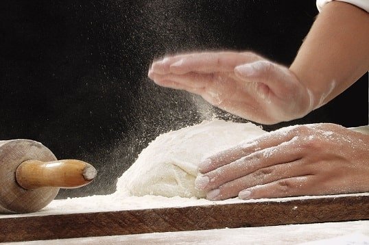 Preparing pizza dough in a kitchen